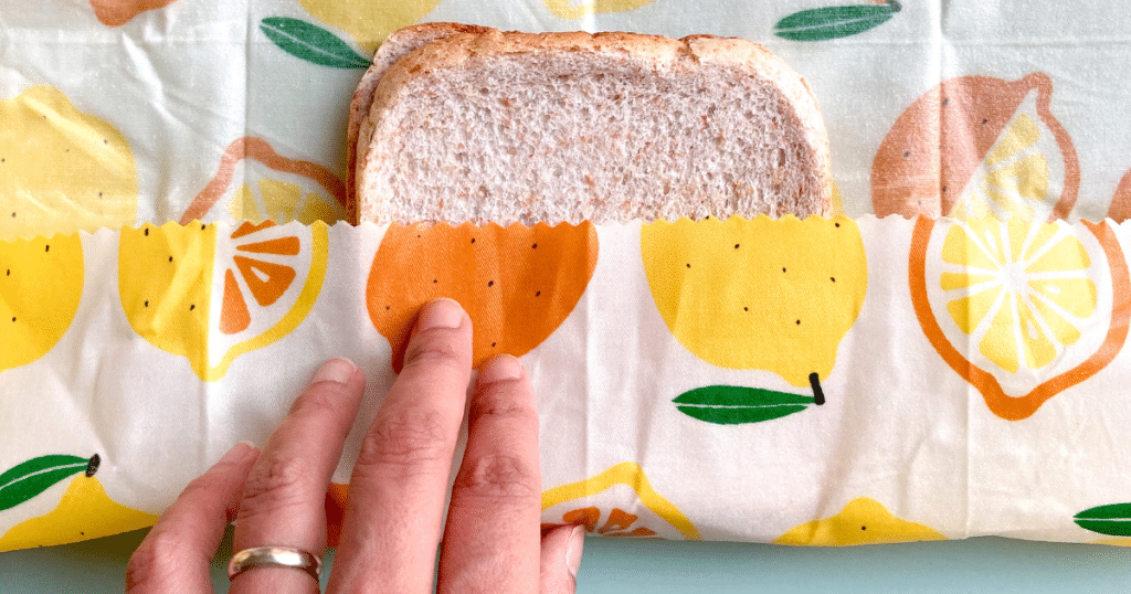 A sandwich being wrapped in beeswax wrap
